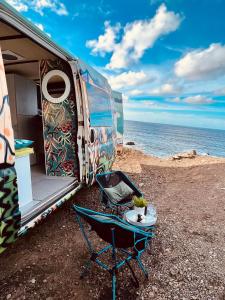 El GuinchoOn Road- feel freedom with campervan!的海边的转折带桌子和椅子