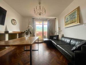 阿斯科利皮切诺L’Attico Sul Fiume center home的客厅配有黑色真皮沙发和桌子