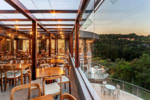 格拉玛多Laghetto Resort Golden Oficial的阳台餐厅,配有桌椅