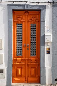 塔维拉Tavira Nomad Guesthouse的大楼一侧的橙色门