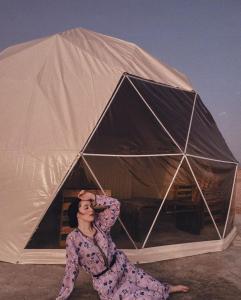 Al WāşilGolden Desert Camp Al Wasil的女人坐在帐篷前