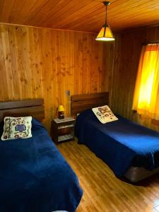 卡布尔瓜Portal Costanera Caburgua的小木屋内一间卧室,配有两张床