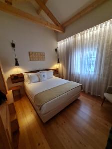 波尔图Porta Nobre - Exclusive Living Hotel的卧室设有一张白色大床和一扇窗户。