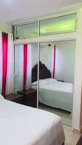 Licey al MedioCómodo apartamento en Santiago的一间卧室配有两张床和镜子