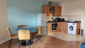 威根Modern 1-Bed Flat in Wigan的厨房配有桌子、洗衣机和烘干机