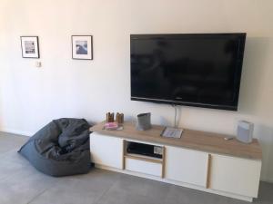 朗克维茨3FLOORS的客厅配有壁挂式大屏幕平面电视