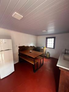 蒂拉登特斯Casa do Chafariz Tiradentes的客厅配有桌子和冰箱