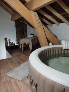 LathuilleLE MAZOT-SPA HIVER ET ETE-Piscine-Proche lac-Charme-Détente的一间带浴缸的浴室,位于阁楼