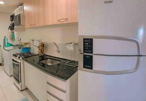 马塞约Apartamento por temporada的一间带水槽和冰箱的小厨房