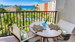 拉海纳Maui Westside Presents: Kaanapali Shores 733 Stunning Ocean Views NEW LISTING的海景阳台上的桌椅