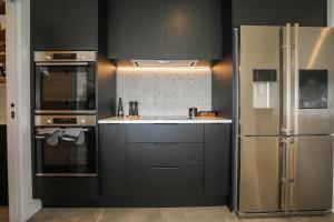 罗托鲁瓦Airport Oasis的厨房配有黑色橱柜和不锈钢冰箱