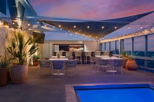 奥斯汀奥斯汀市中心欧尼酒店的一个带桌椅的屋顶露台和游泳池