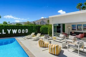 棕榈泉Palm Springs Luxury Home With a POOL, Next to Downtown & Airport的一个带椅子的庭院和一个游泳池
