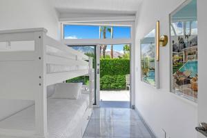 棕榈泉Palm Springs Luxury Home With a POOL, Next to Downtown & Airport的一间白色卧室,配有双层床和一个游泳池