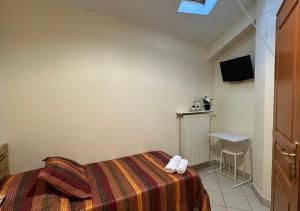 奥贝维利埃维克多雨果酒店的一间卧室配有一张床、一张桌子和一台电视