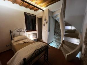 比森齐奥营casatorre medioevale的一间卧室设有一张床和一个螺旋楼梯
