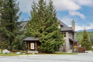 惠斯勒Blackcomb Greens 20 - Secure Parking, Shared Hot Tub, BBQ, Free Shuttle - Whistler Platinum的前面有一棵大树的房子