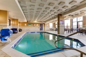 圣彼得斯圣路易斯圣彼得斯德鲁套房酒店的酒店大堂的游泳池,配有桌椅