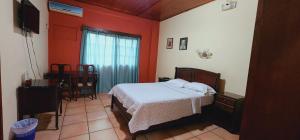 特古西加尔巴Hotel Alsacia的一间设有床铺的卧室,位于一个红色墙壁的房间
