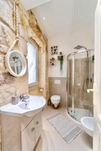 萨萨里LA SUITE DE TURRITAN的一间带水槽、淋浴和卫生间的浴室