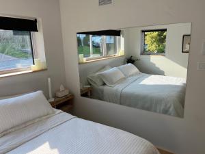 萨格奈Magical Loft : Breathtaking View & Cozy Fireplace的一间卧室设有两张床和大镜子