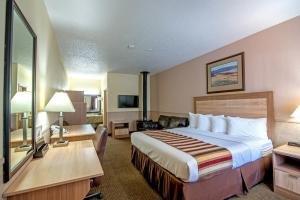 格伦伍德温泉Silver Spruce Inn的酒店客房设有一张大床和一张书桌。