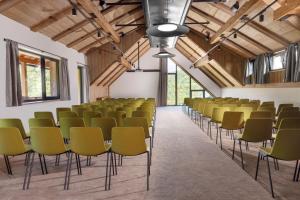 维特科维采Aldrov Resort的一间设有一排椅子的客房,位于一栋带木制天花板的建筑内