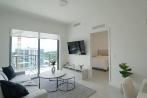 迈阿密Brand New Apartment in Brickell with parking的白色的客厅配有沙发和桌子