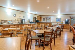 格伦伍德温泉Silver Spruce Inn的餐厅设有木桌、椅子和柜台