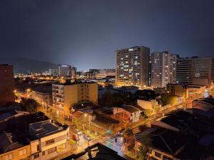 特木科Departamento Centro Lynch II的夜间有建筑和街灯的城市