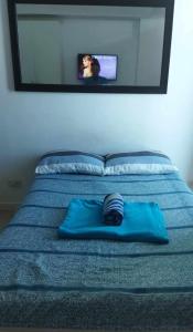 马尼拉SM Bicutan Rooms By M的蓝色枕头坐在带镜子的床上