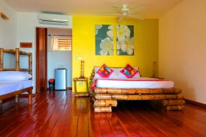 马拉帕斯加特潘尼海滩聚居村的一间卧室设有一张床和黄色的墙壁