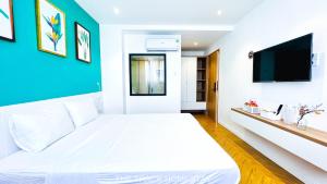 Cam LâmThe Track Homestay的卧室配有一张白色大床和蓝色的墙壁