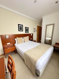 卡尔达斯达·赖尼亚欧亚酒店的一间卧室配有一张大床和镜子
