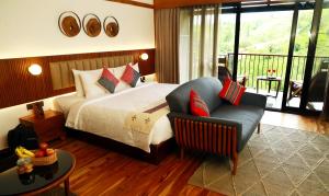 乌提WelcomHeritage Ayatana, Ooty的配有一张床和一把椅子的酒店客房