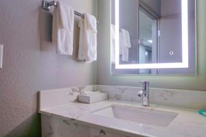 罗克福德速8罗克福德酒店的浴室配有盥洗盆、镜子和毛巾
