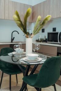 约翰内斯堡Green with Envy-Luxury Apartment- No Loadshedding的一张带绿椅的餐桌和一间厨房