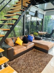 Ban Thap NangPeaceful & Contemporary Duplex Escape的客厅配有带彩色枕头的棕色皮沙发