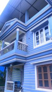 莫尔吉姆Vyana villa rooms的蓝色房子的顶部设有阳台