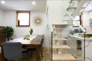 纽约Beautifully Designed 3 BR Apartment的一间带桌子和楼梯的用餐室