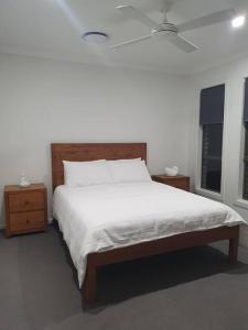 圣殿海岬JervisBayStays TheSanctuaryFour的卧室设有一张白色大床和两个窗户。