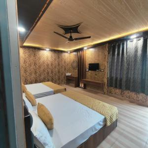 穆克缇斯瓦Hotel Pearl Residency的一间卧室配有两张床和吊扇