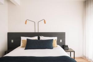 索伦托索伦托酒店的一间卧室配有一张大床和黑色床头板