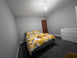 CanleyModern Room Close to Warwick University的一间卧室配有一张黄色和白色的被子。