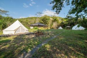 美作Glamchette Okayama -Glamping & Auto Camp- - Vacation STAY 44593v的一组帐篷,位于一个有桌子的场地内