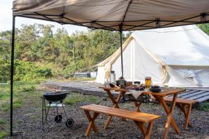 美作Glamchette Okayama -Glamping & Auto Camp- - Vacation STAY 44575v的配有烧烤架和帐篷的野餐桌