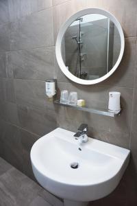 萨图恩Vila Navona的浴室设有白色水槽和镜子
