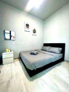 哥打京那巴鲁Botiza Suites at Jesselton Quay的一间卧室设有一张大床和白色的墙壁