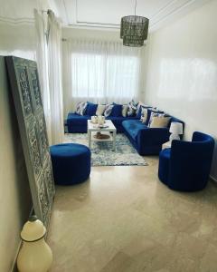 卡萨布兰卡Petit appartement 68m2 quartier Bourgogne的客厅配有蓝色的沙发和蓝色的椅子