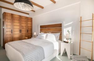 费拉Apeiron Blue Santorini - Sustainable Adults Only 14 Plus的卧室配有白色的床和木制床头板